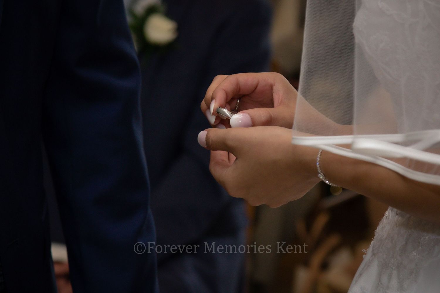 Close-up of hands exchanging rings during wedding ceremony.