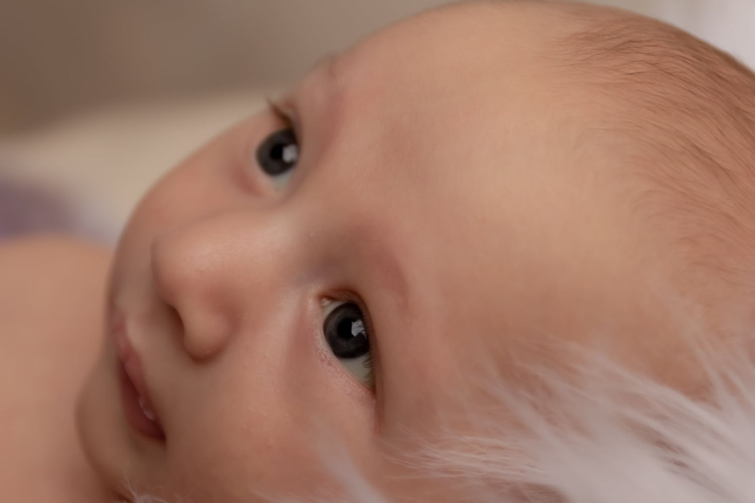 Extreme close-up of a baby's face with bright eyes looking upward.