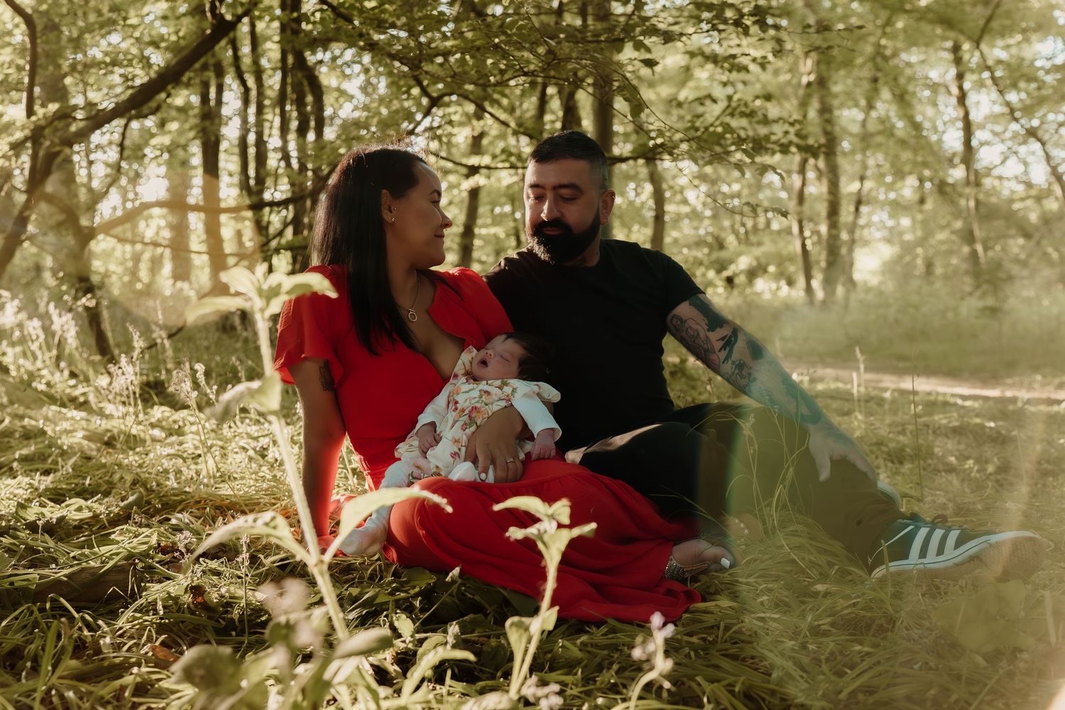 Family enjoying quality time together in a sun-dappled forest setting.