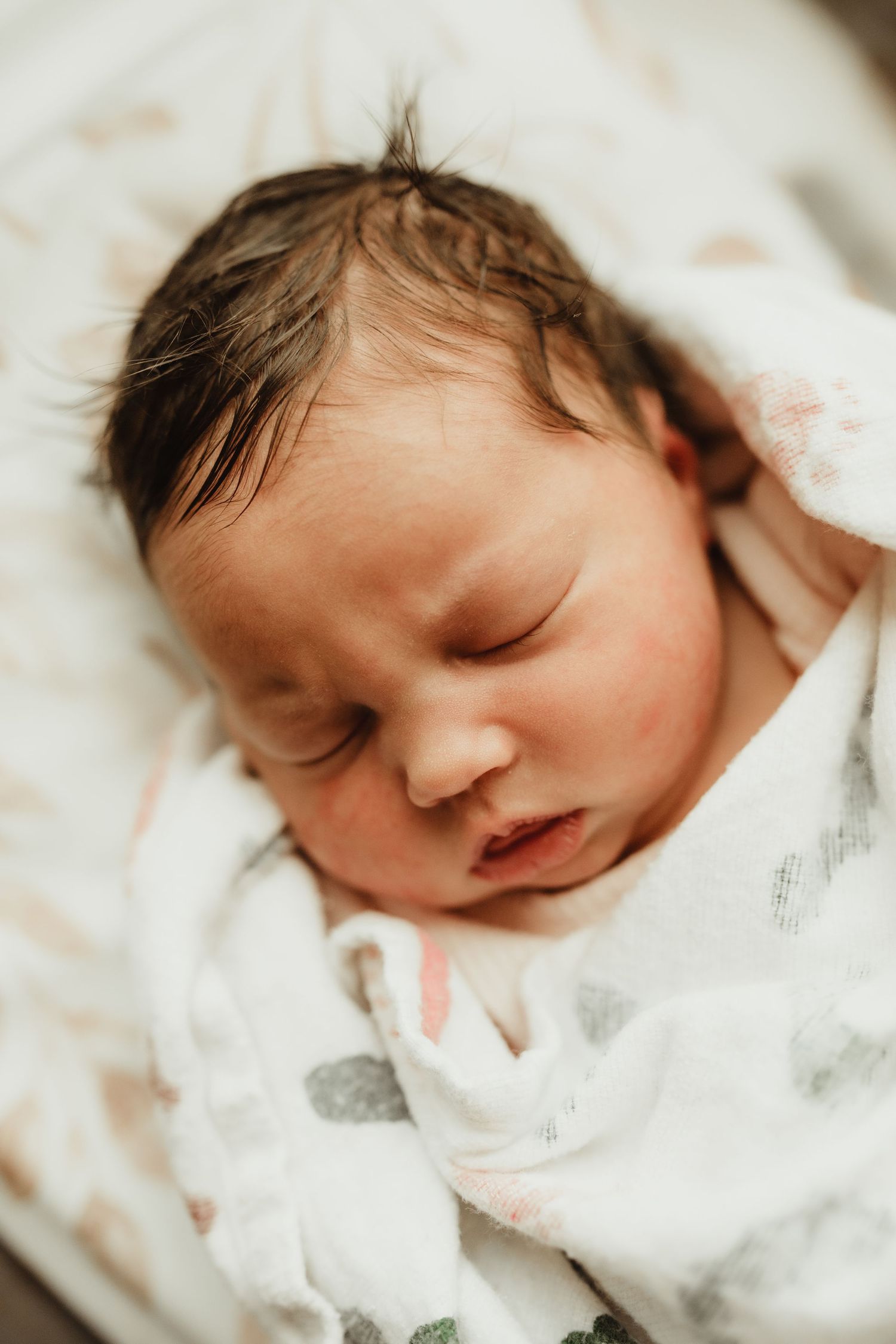 A sleeping newborn baby swaddled in white blankets shown from multiple angles.