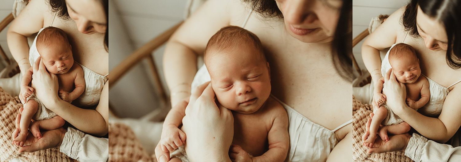 Peaceful newborn baby sleeping in mother's gentle arms during a soft natural light newborn photography session.
