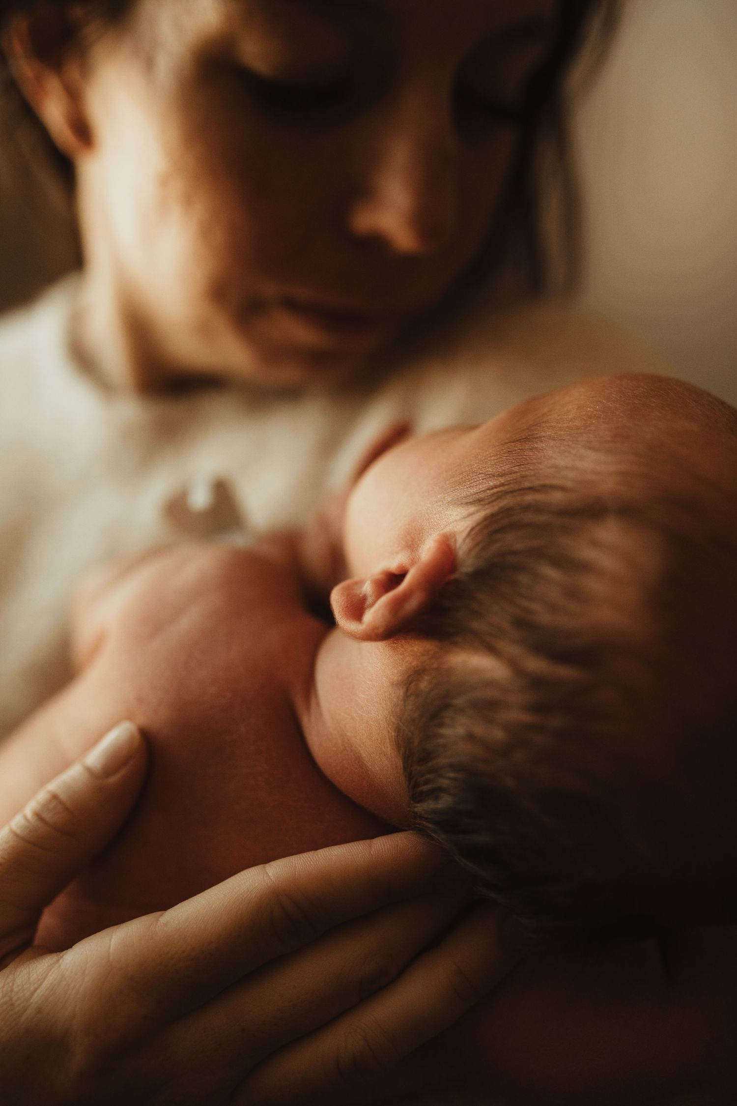 Close-up artistic series of an infant's hands grasping in soft, warm lighting creating an intimate atmosphere.
