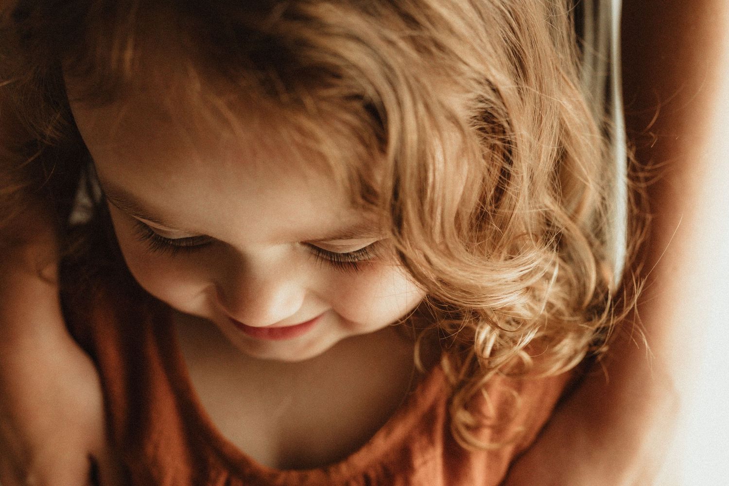 A series of close-up portraits showing warm expressions and soft lighting against dark backgrounds.