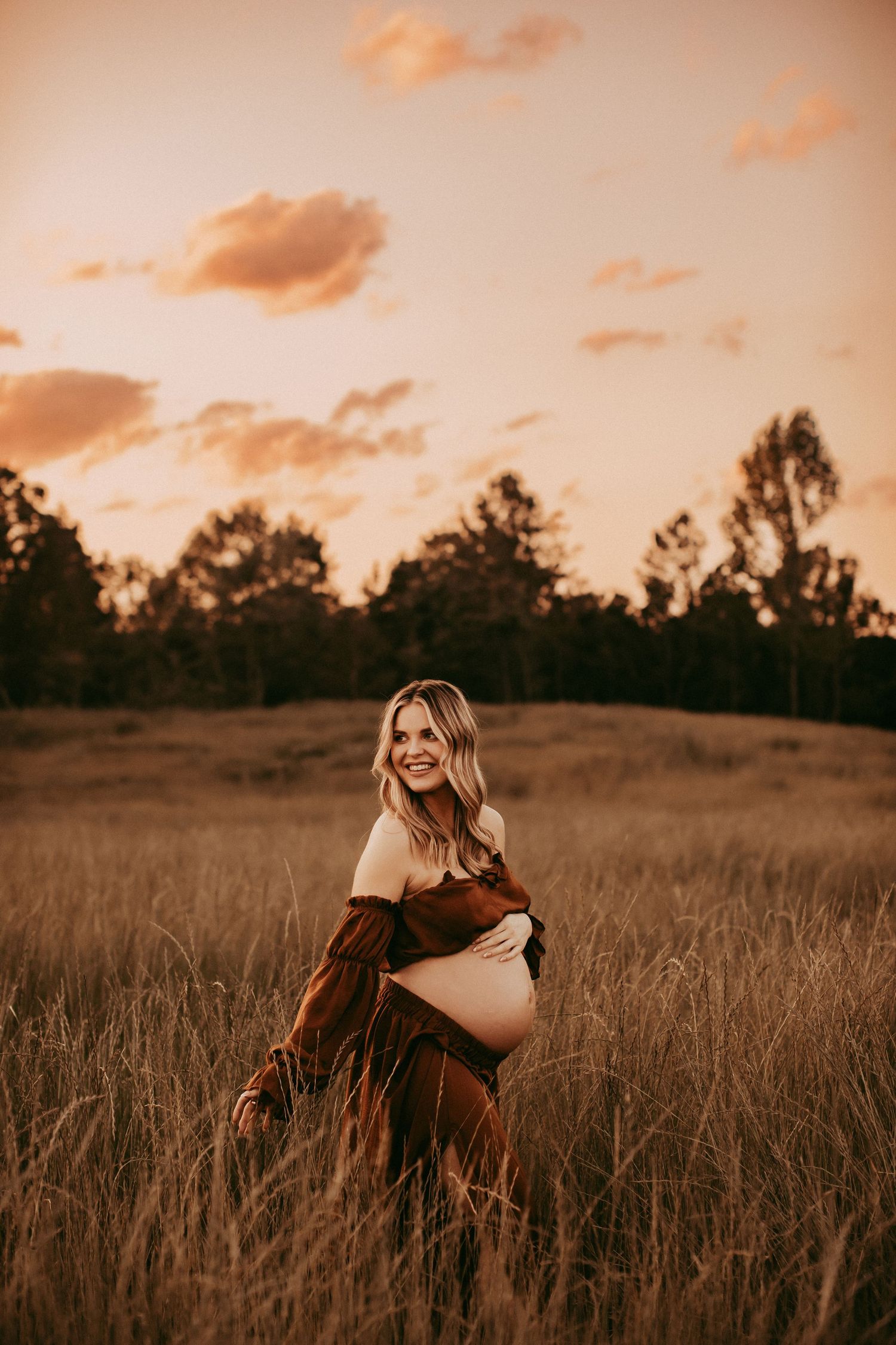 A golden sunset illuminates a serene field of tall grass as a figure moves peacefully through the landscape.