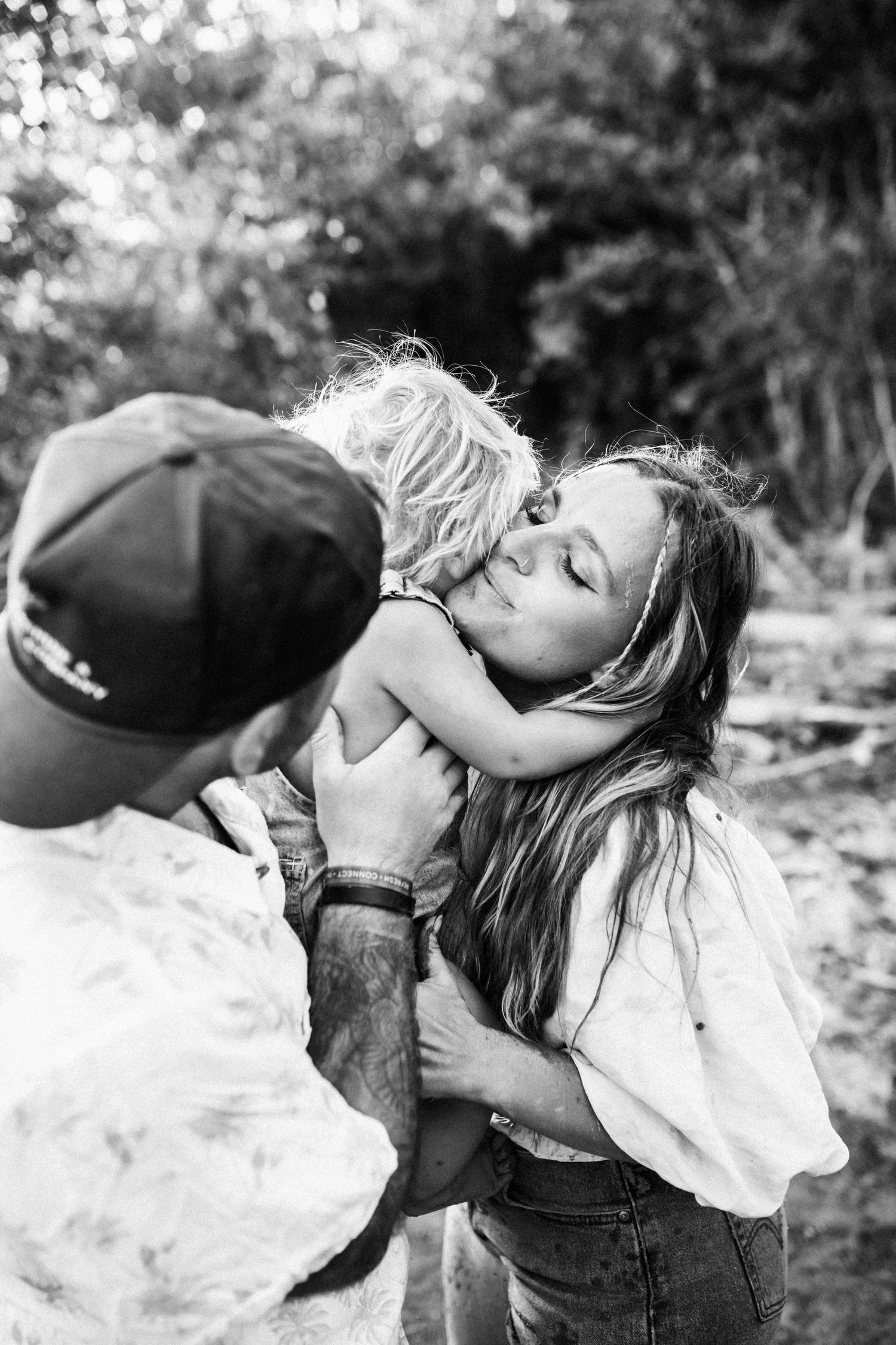 A heartwarming black and white photo set shows a small child tenderly kissing a friendly dog outdoors.