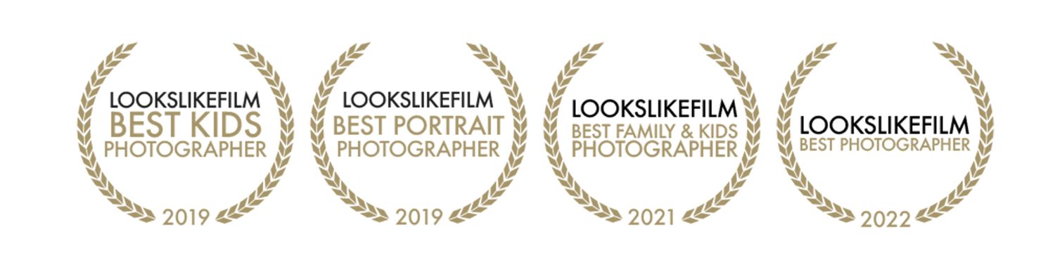 A row of golden laurel wreath awards and film festival recognition badges arranged horizontally.