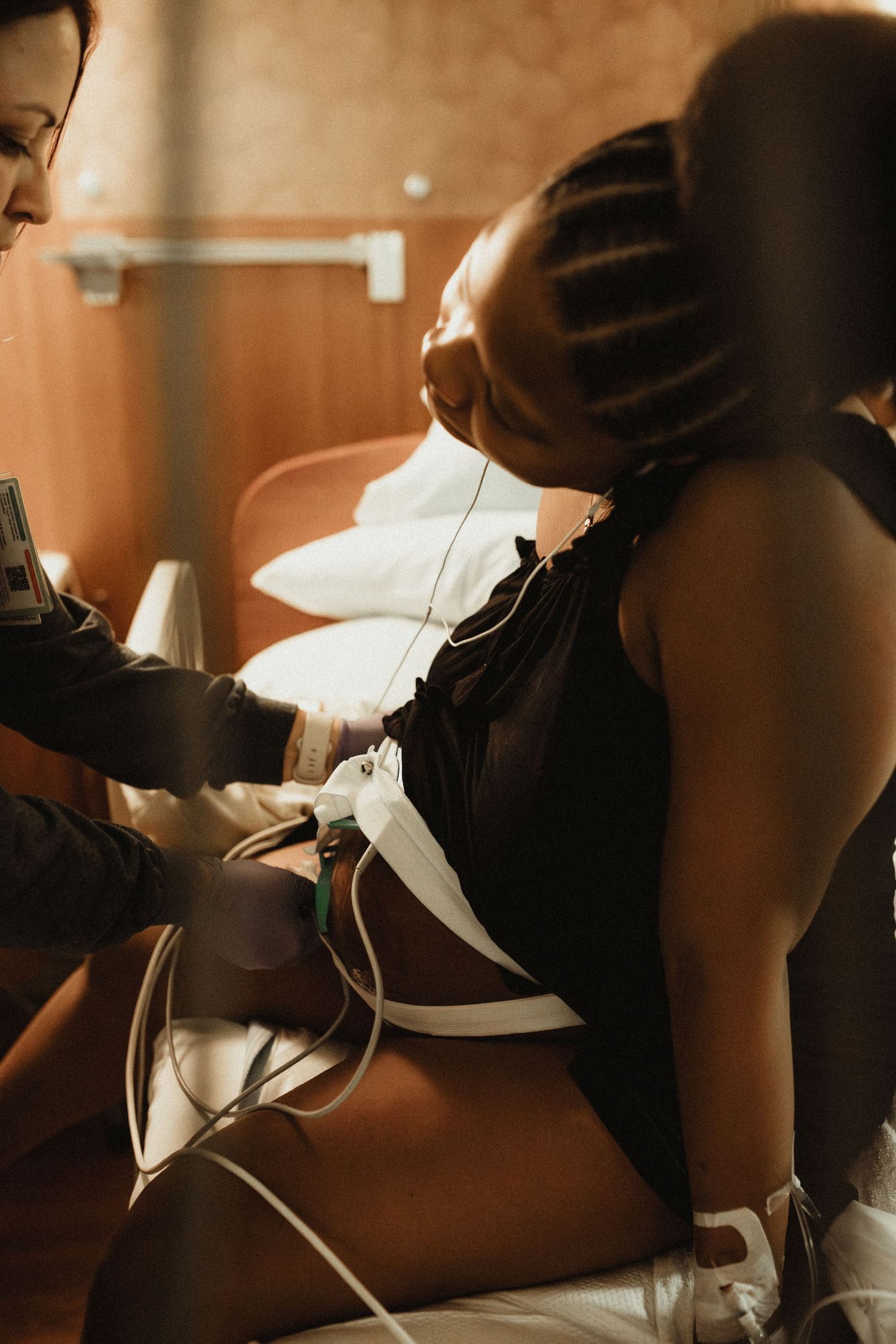 A person in black sports attire relaxes during a massage therapy session in warm lighting.