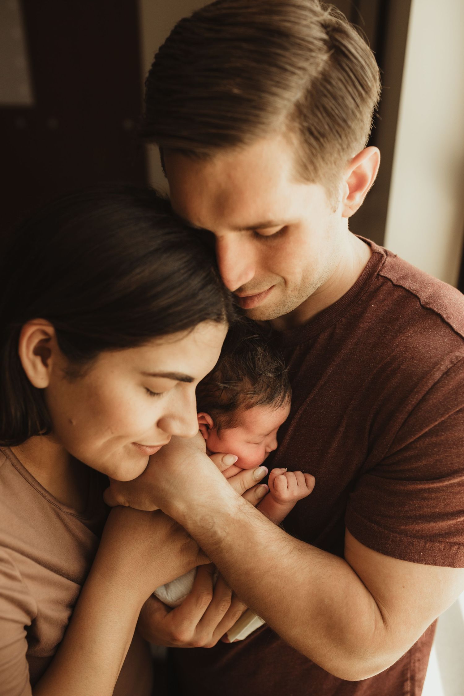 Four connected photos showing tender moments between new parents and their newborn baby in soft natural light.