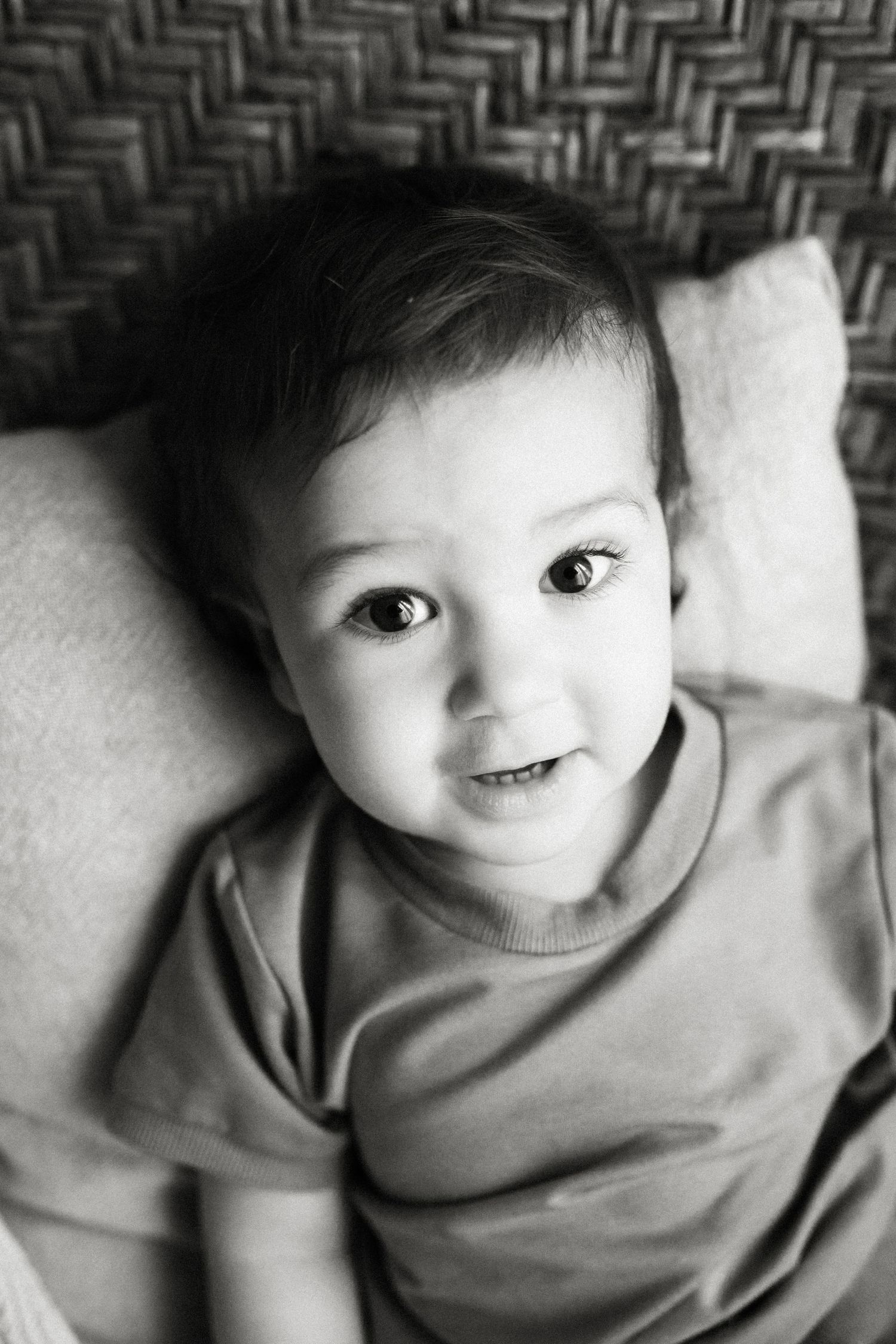 Black and white close-up photos show a child in a sweater making playful expressions at the camera.
