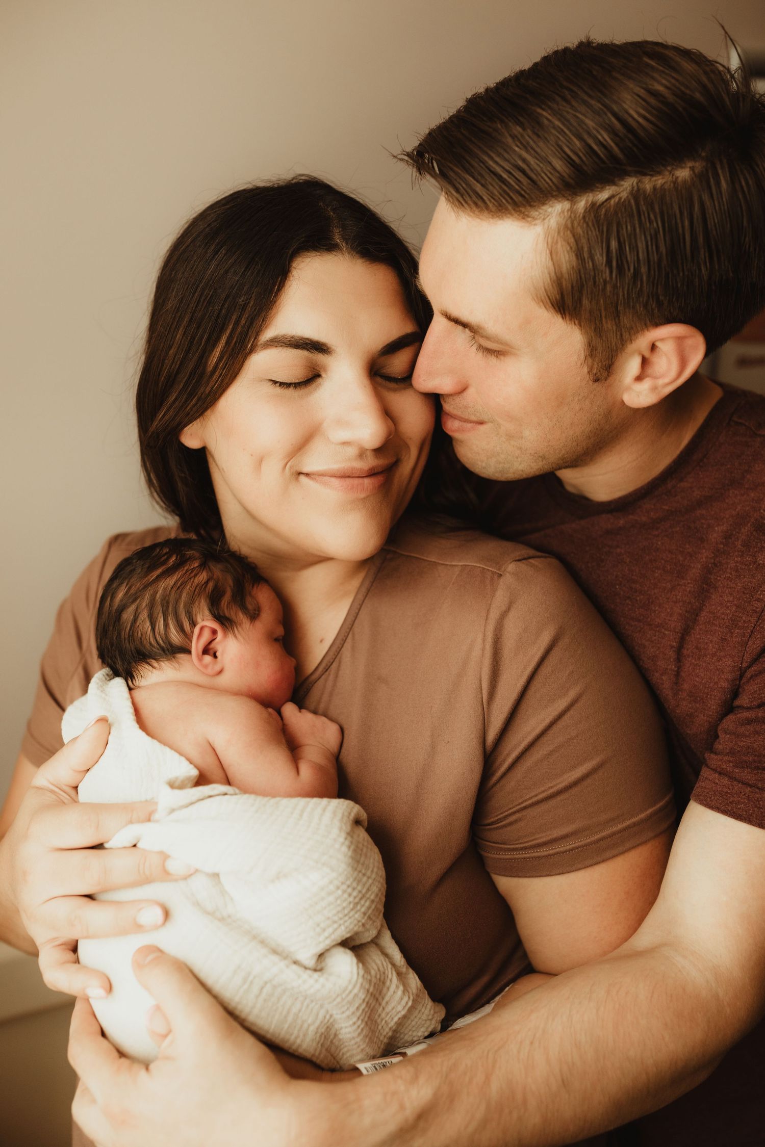 A series of intimate family portraits showing tender moments between parents and their newborn baby in warm neutral tones.