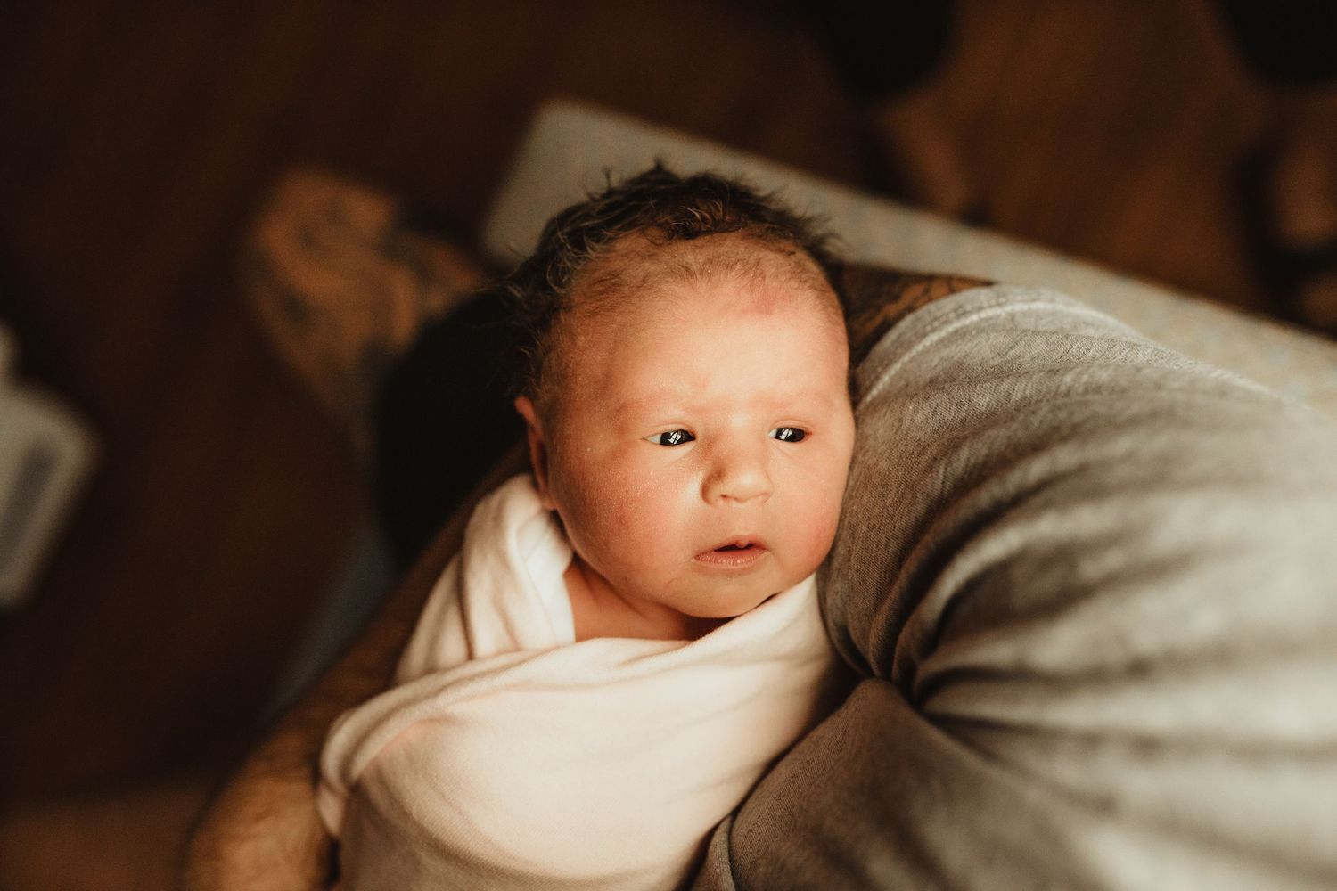 A sequence of tender newborn photos capturing peaceful sleeping moments on soft beige sheets in warm lighting.