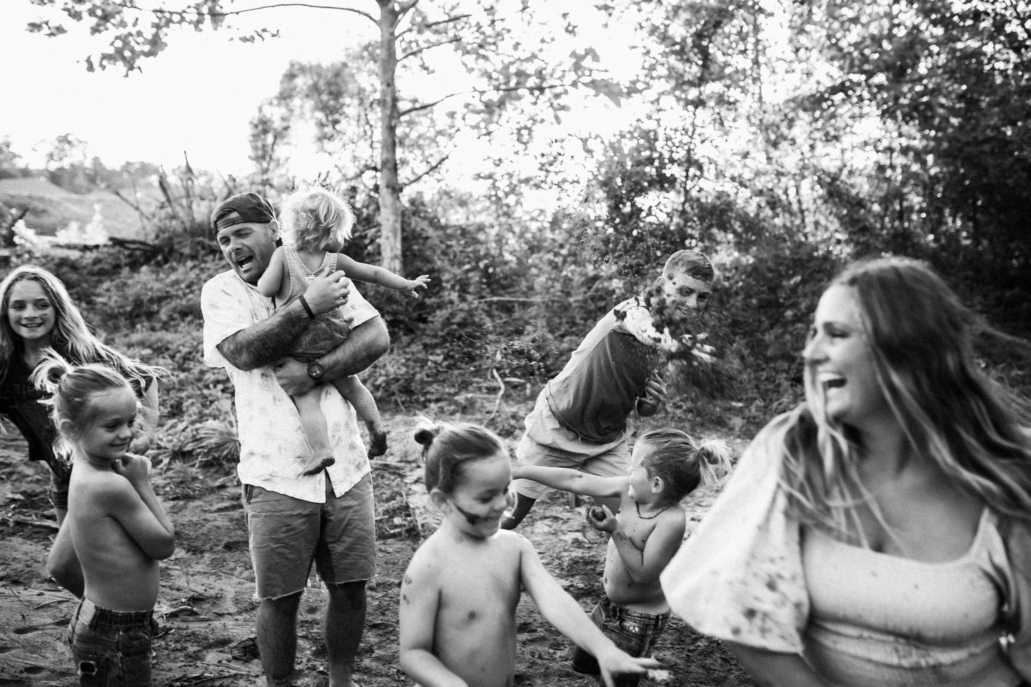 Group enjoying a fun candid moment together in a relaxed outdoor black and white photoshoot.
