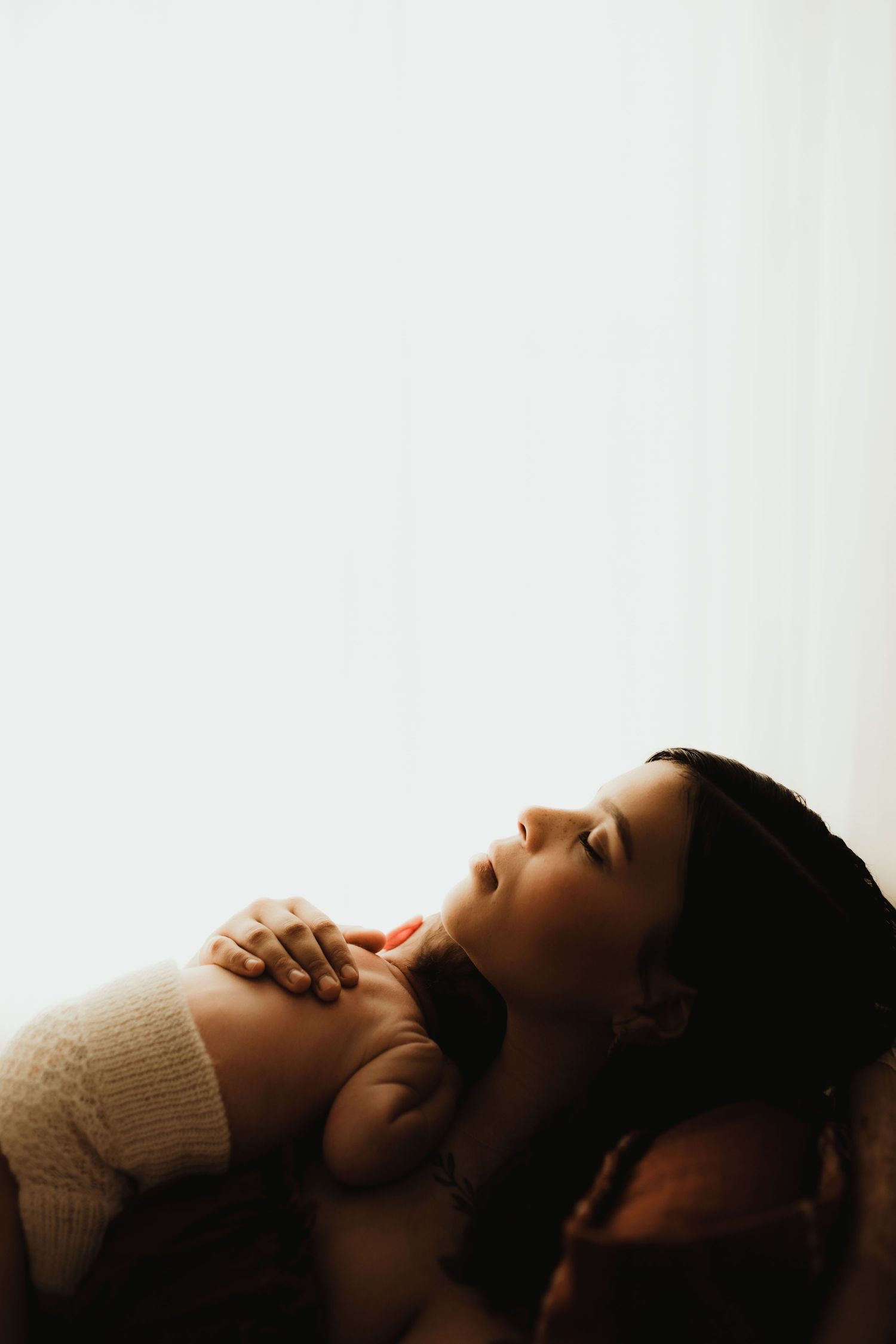 A darkly lit artistic portrait shows five progressive views of a resting figure against a light background.