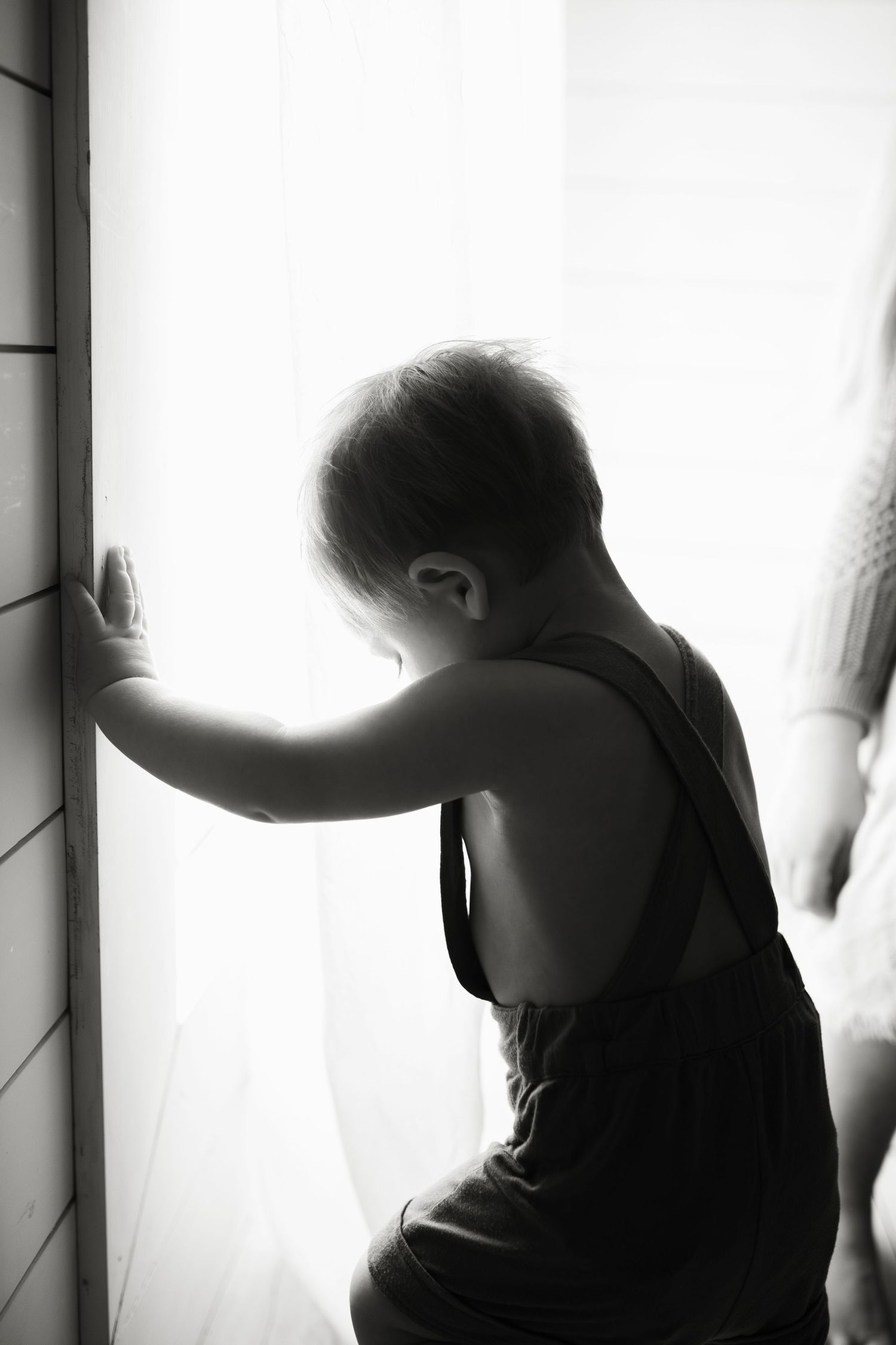 A black and white artistic photo sequence showing silhouetted figures against bright windows in a moody composition.