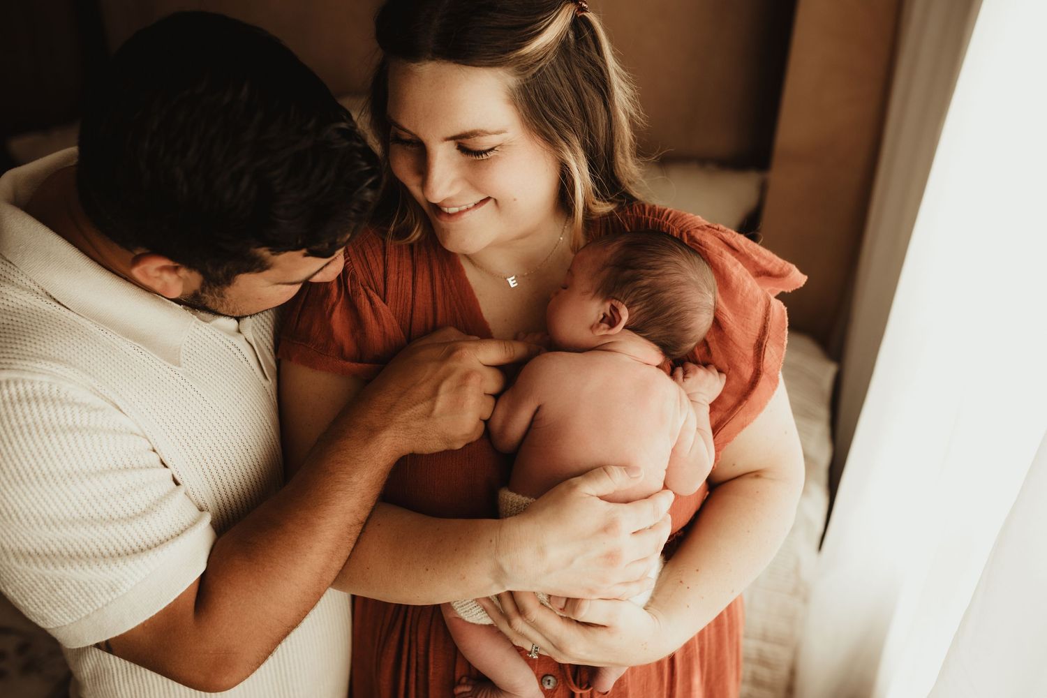 Loving family moment captured in muted tones against a neutral background.