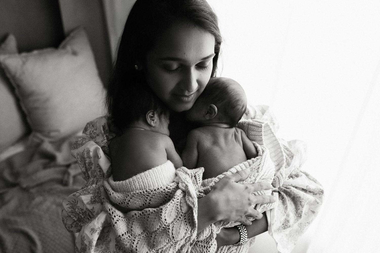 A series of black and white intimate photos showing tender moments between a parent and baby.