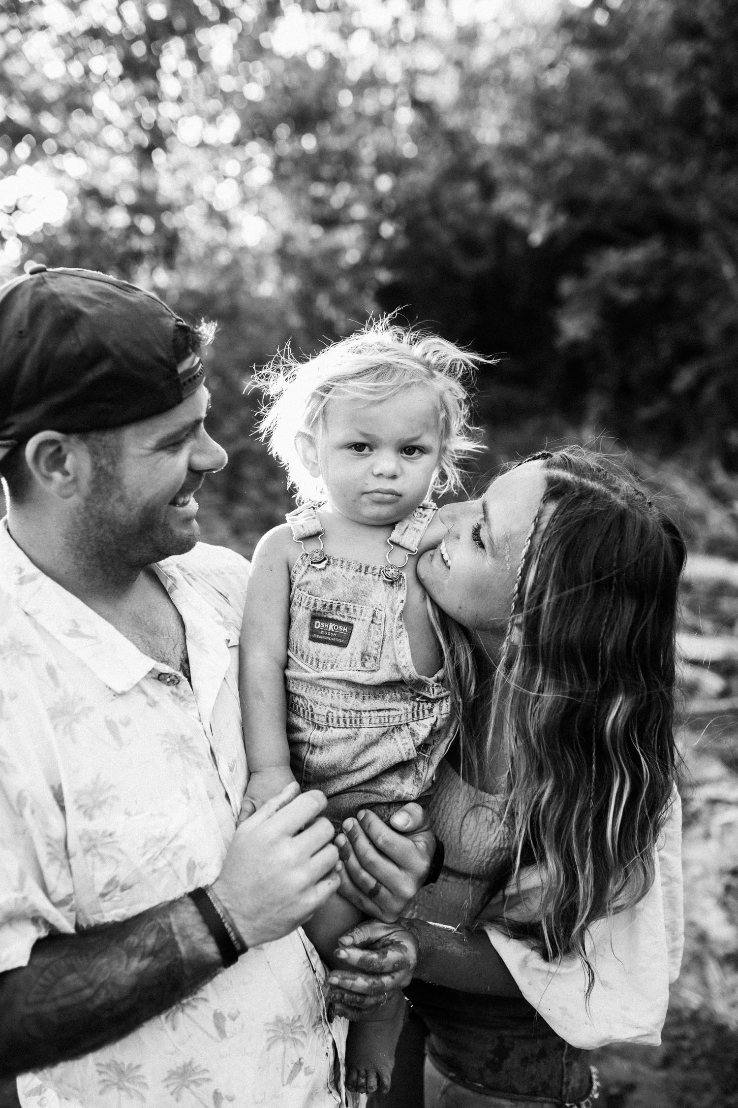 A collection of black and white photos showing intimate family moments outdoors in natural light.