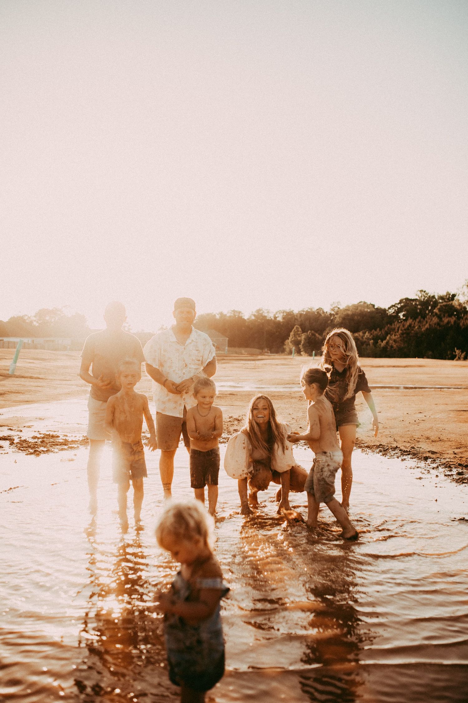 A group enjoying a sunset beach day together splashing in the warm ocean waters.