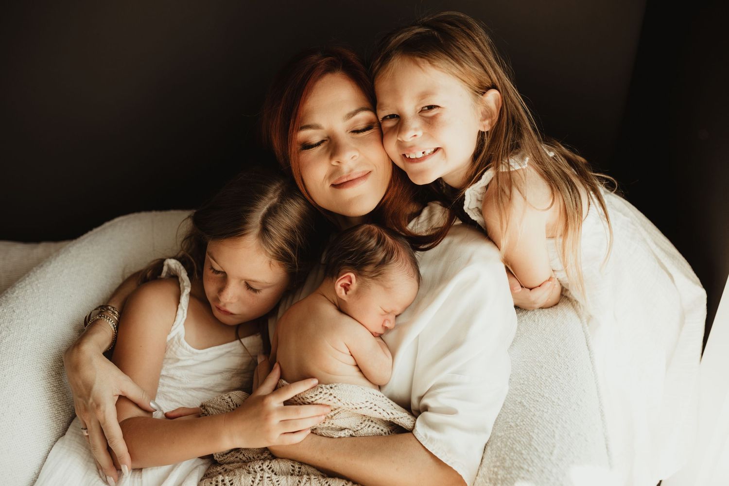 A heartwarming collage of family photos showing tender moments between siblings together on a white bed.