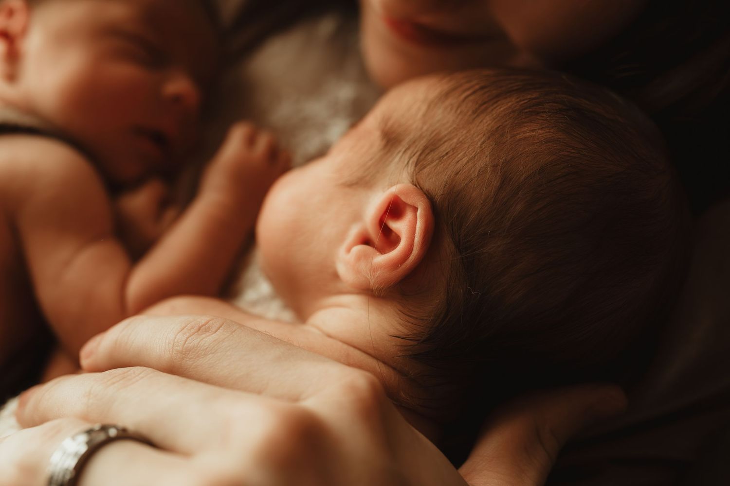 A series of intimate black and white photos showing tender moments between parent and baby.