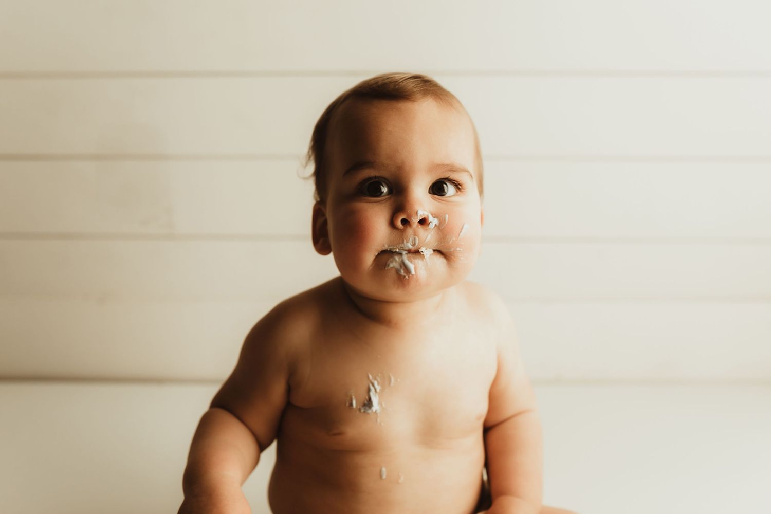 A series of six sepia-toned photos showing a baby's different expressions and poses on a light background.