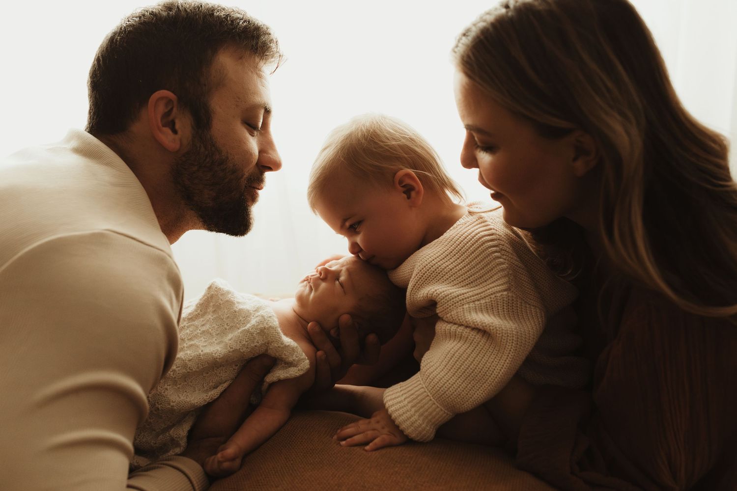 Tender family photoshoot with soft natural lighting and minimalist composition.