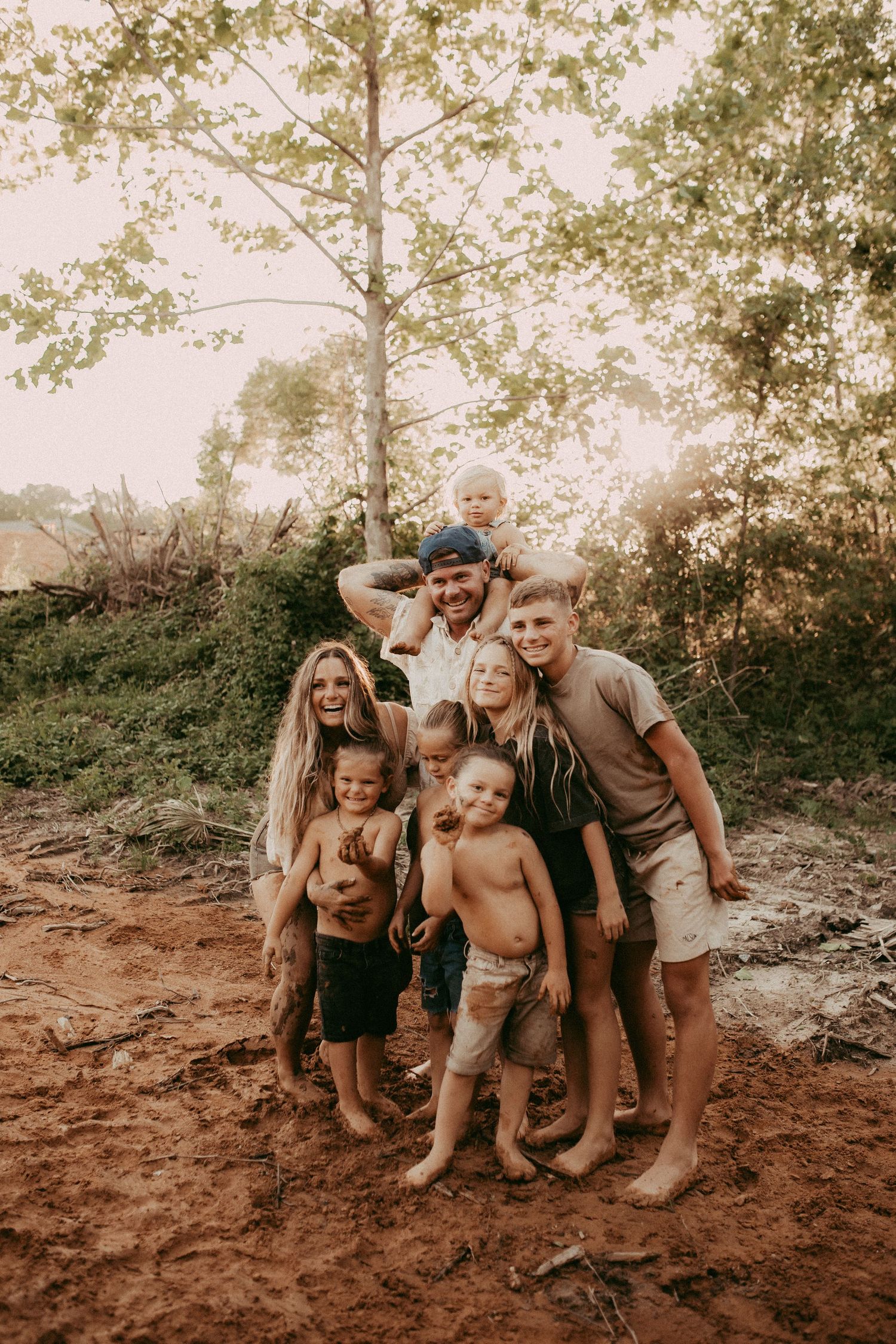 A playful outdoor family photoshoot in sequence showing progressive interaction in a natural setting with reddish soil.