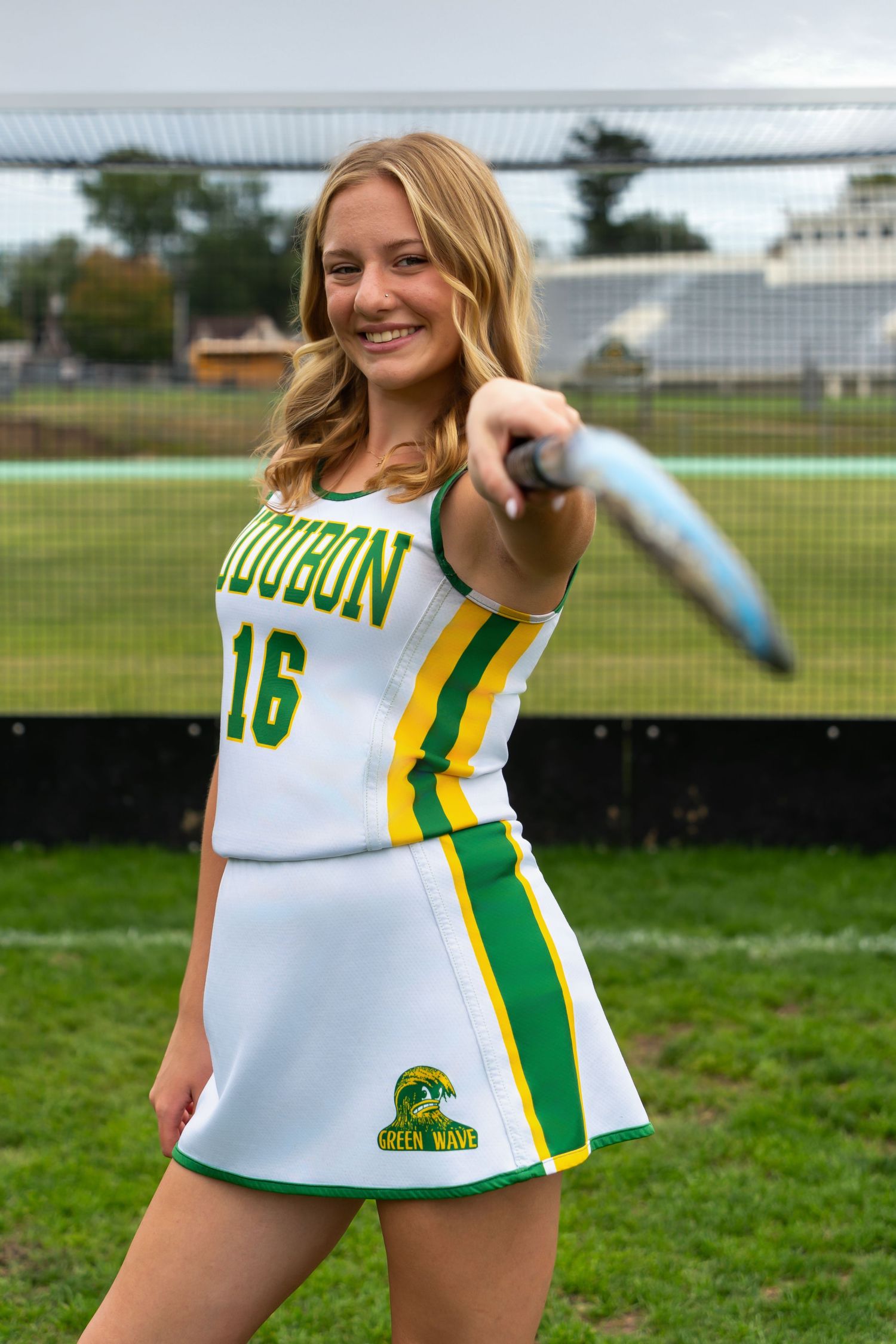 Athletic jersey number 16 in white and green colors displayed on grassy sports field.