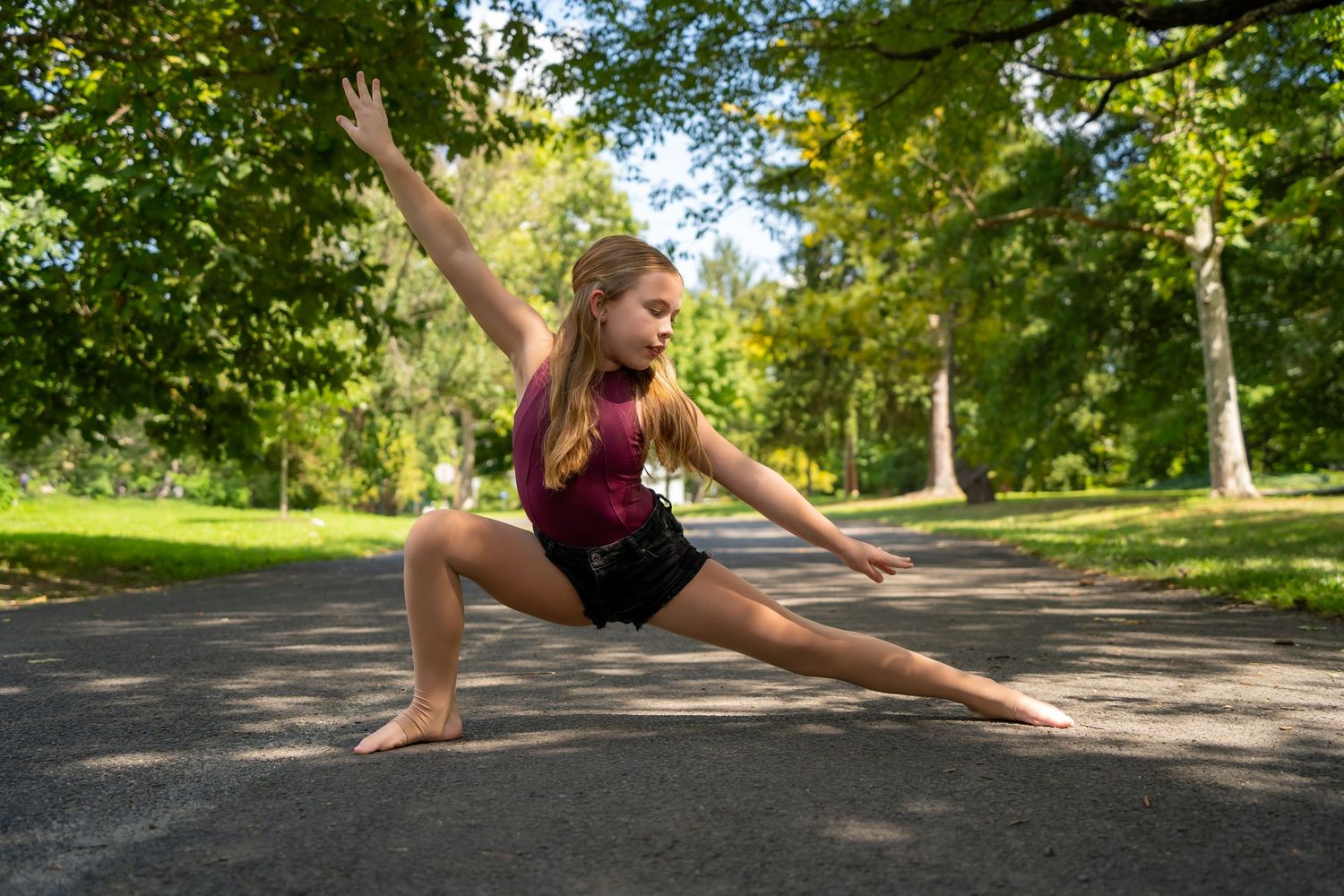 Series of graceful dance poses on a tree-lined path during summer.