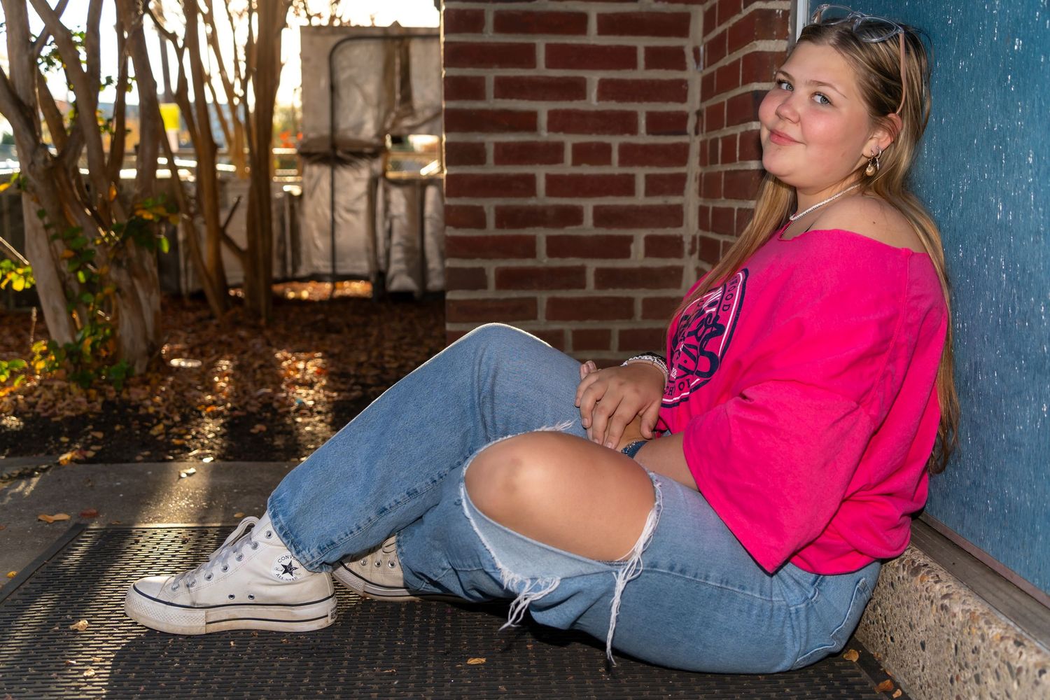 Series of casual poses against a brick wall with blue column detail.