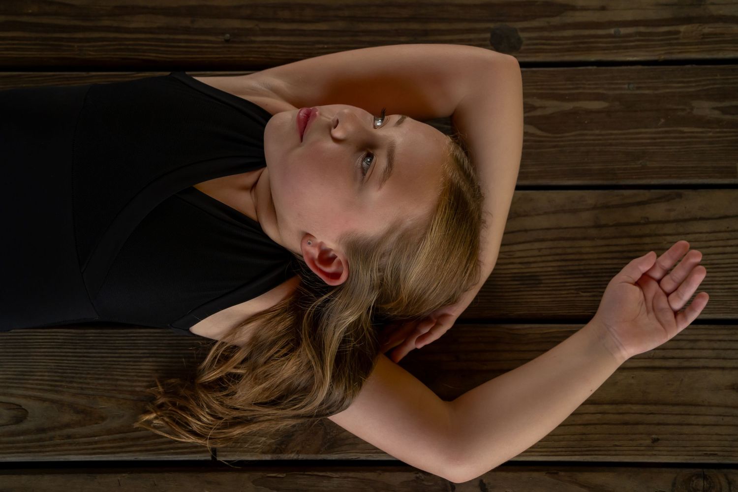 Artistic portrait series on wooden planks with dramatic lighting and shadows.