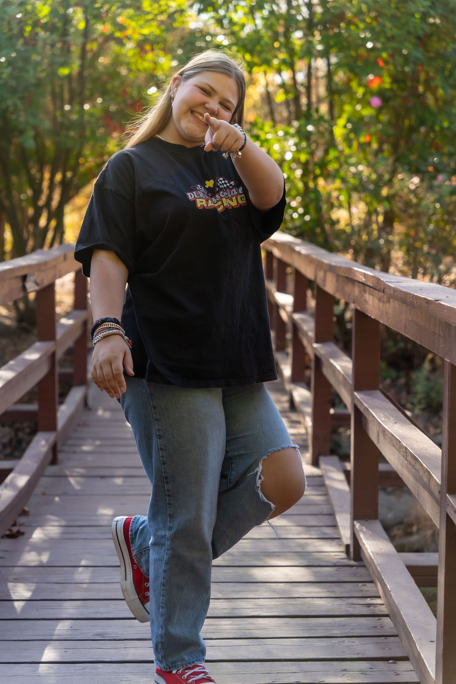 Series of playful poses on a wooden boardwalk through natural scenery.