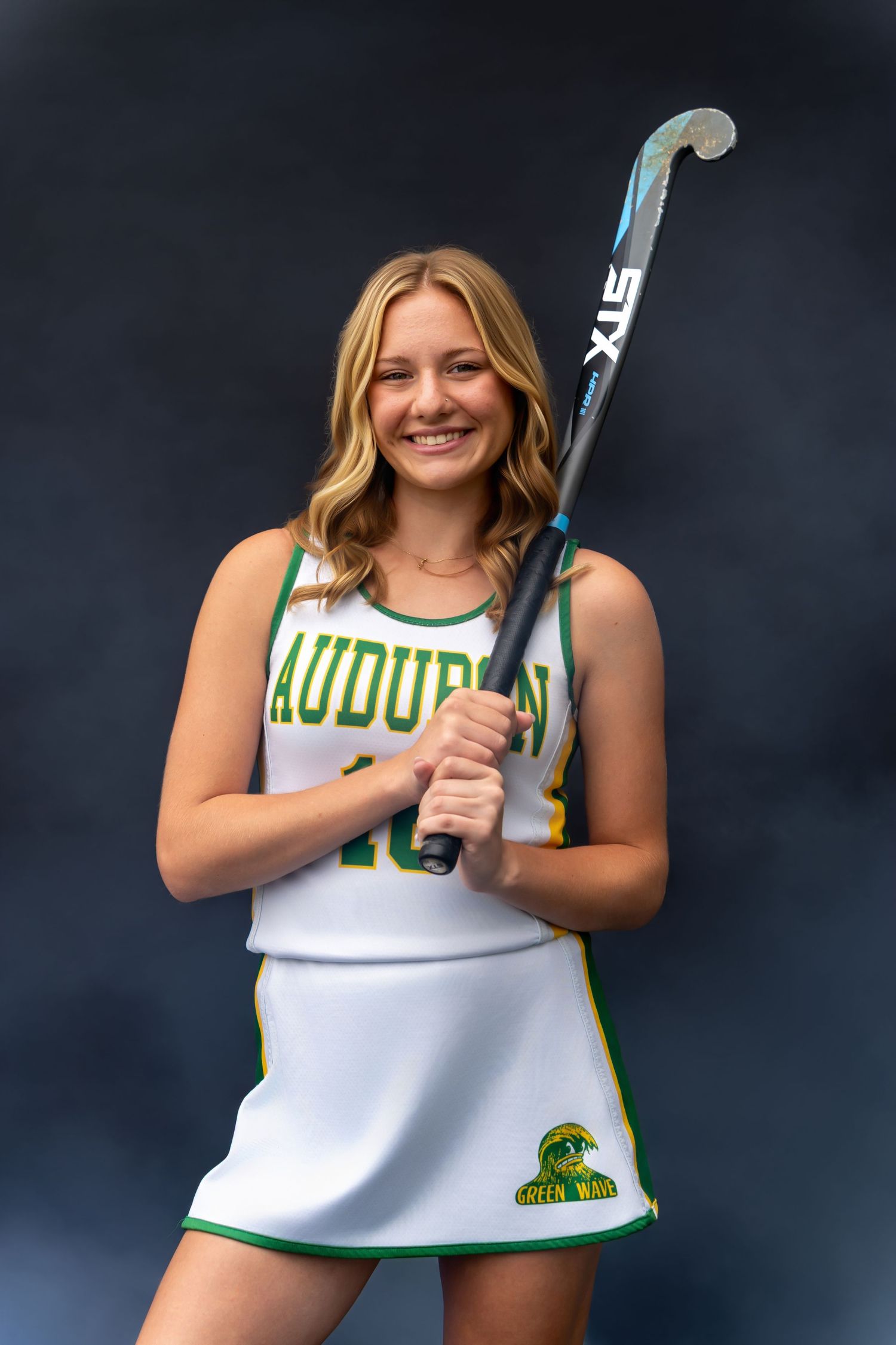 Cheerleader in white and green uniform poses with pom poms against dark background in series of action shots.