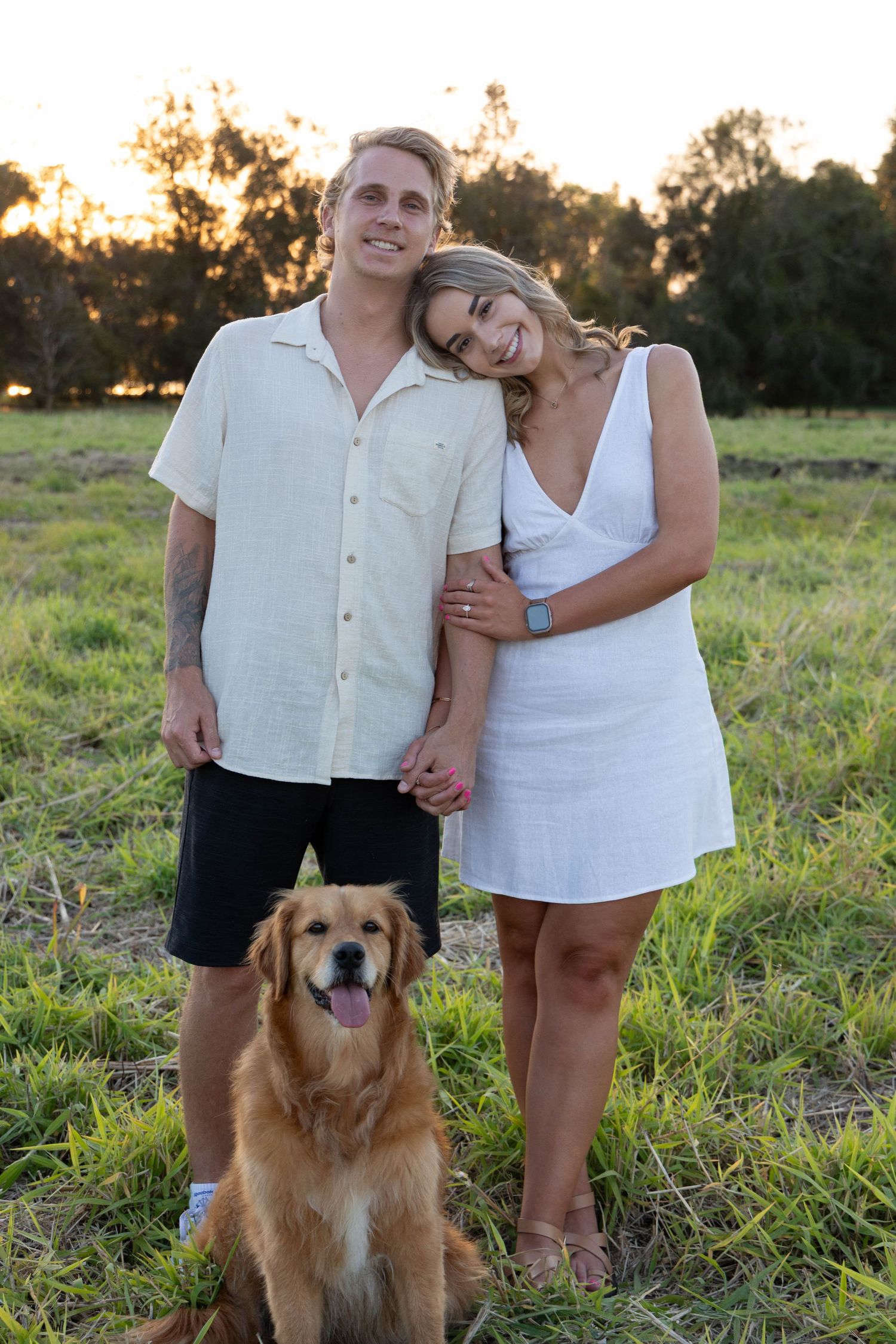 Engagement photos in a field with their dog.