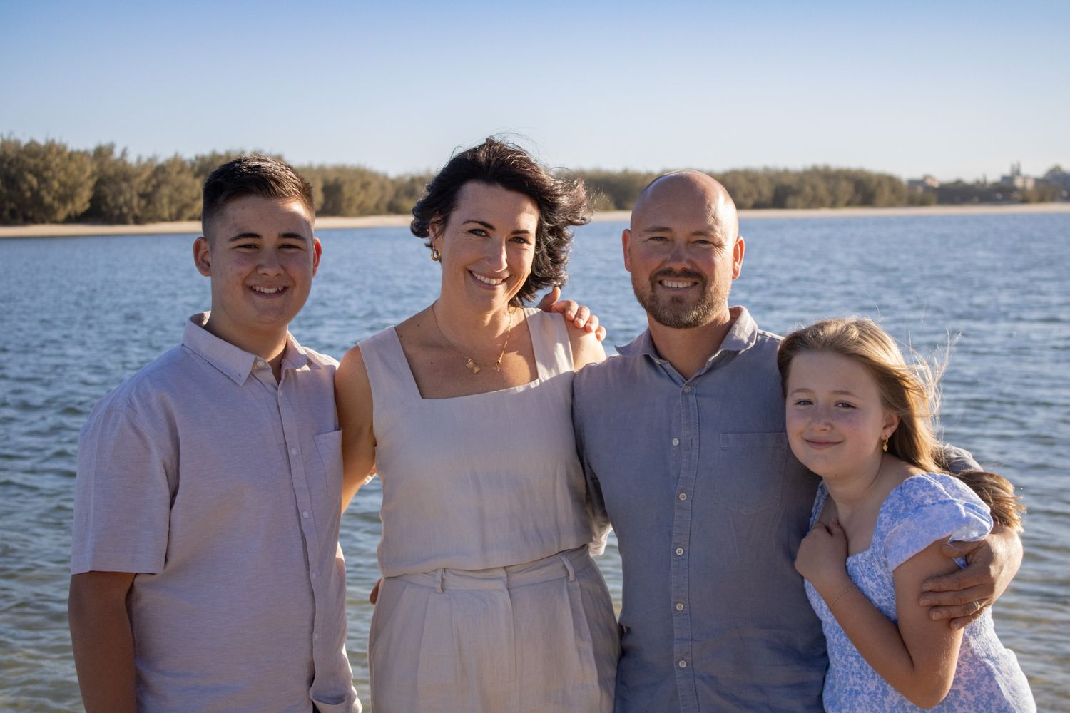 A family posing for a family photo on the beach.