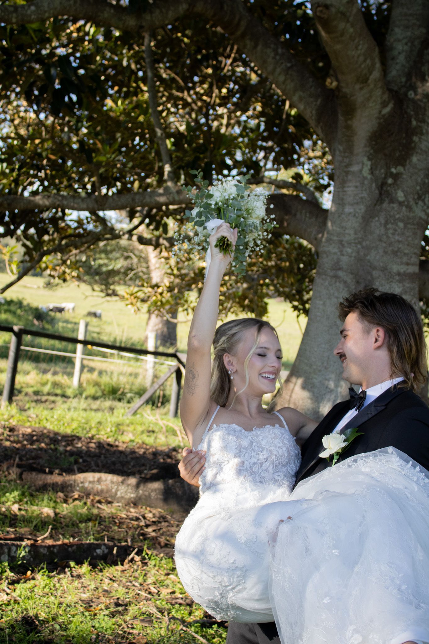 A married couple swinging his wife in his arms.