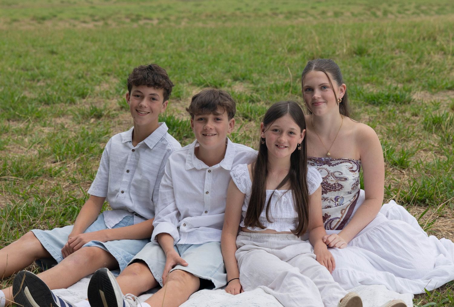 The siblings of a family sitting together for a photo.
