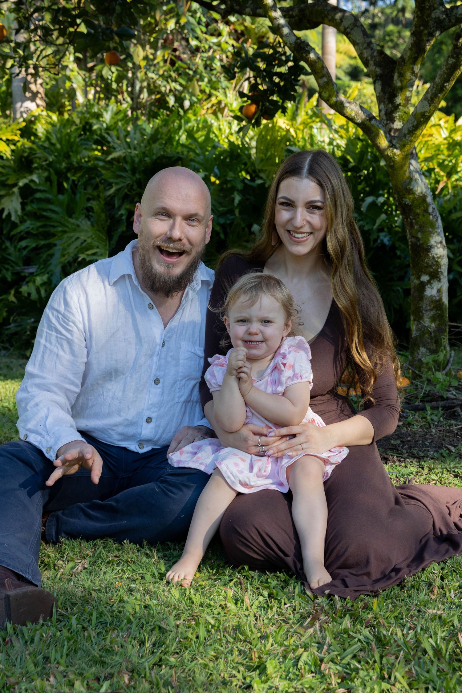 Family photos in their backyard under an orange tree.