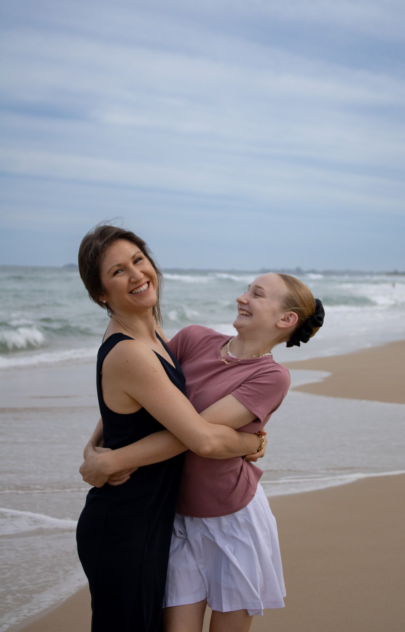 A photo of a mum and daughter sharing a tender moment, smiling and enjoying each other’s company during their photoshoot.
