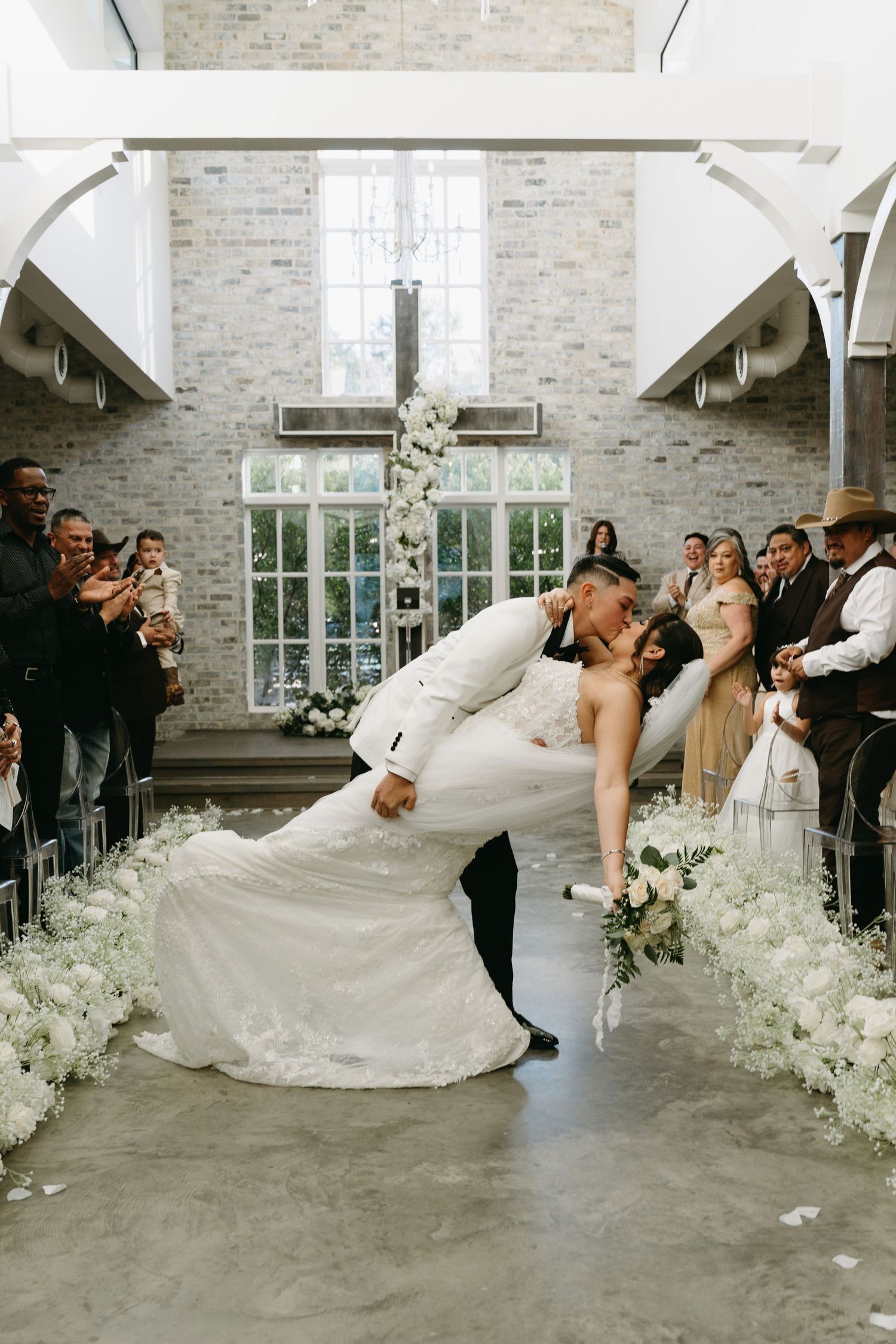 A sequence of wedding photos showing a couple performing a romantic dip dance move in an elegant white brick venue.