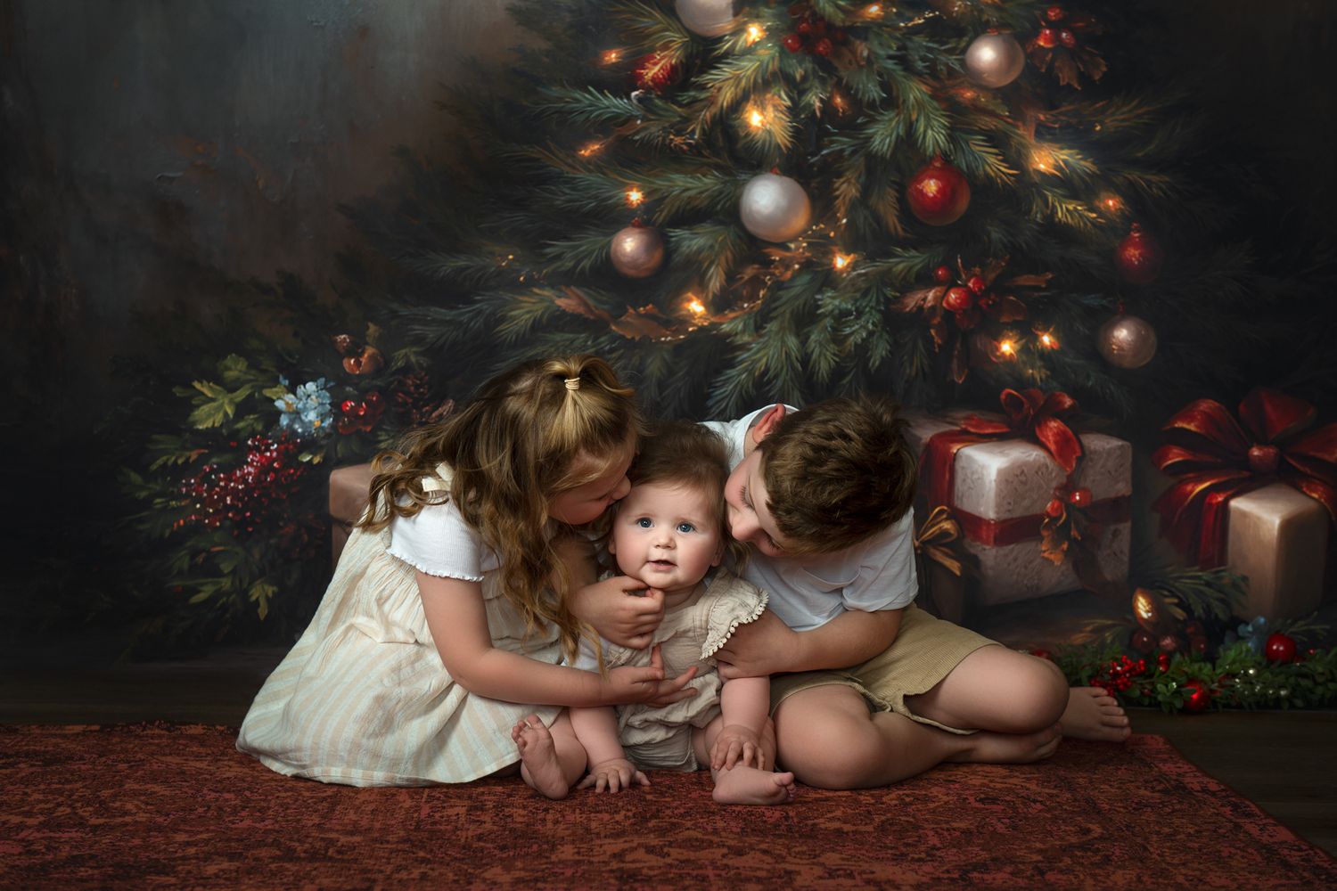 Children sit on floor near Christmas tree with wrapped presents and festive holiday decorations.