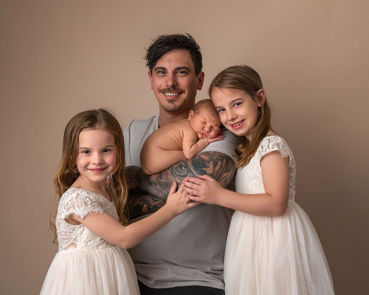 Family portrait series showing tender moments between parent and children in white dresses.