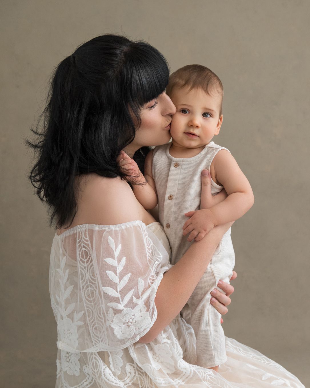 Delicate portraits featuring white lace dresses against a neutral studio background.