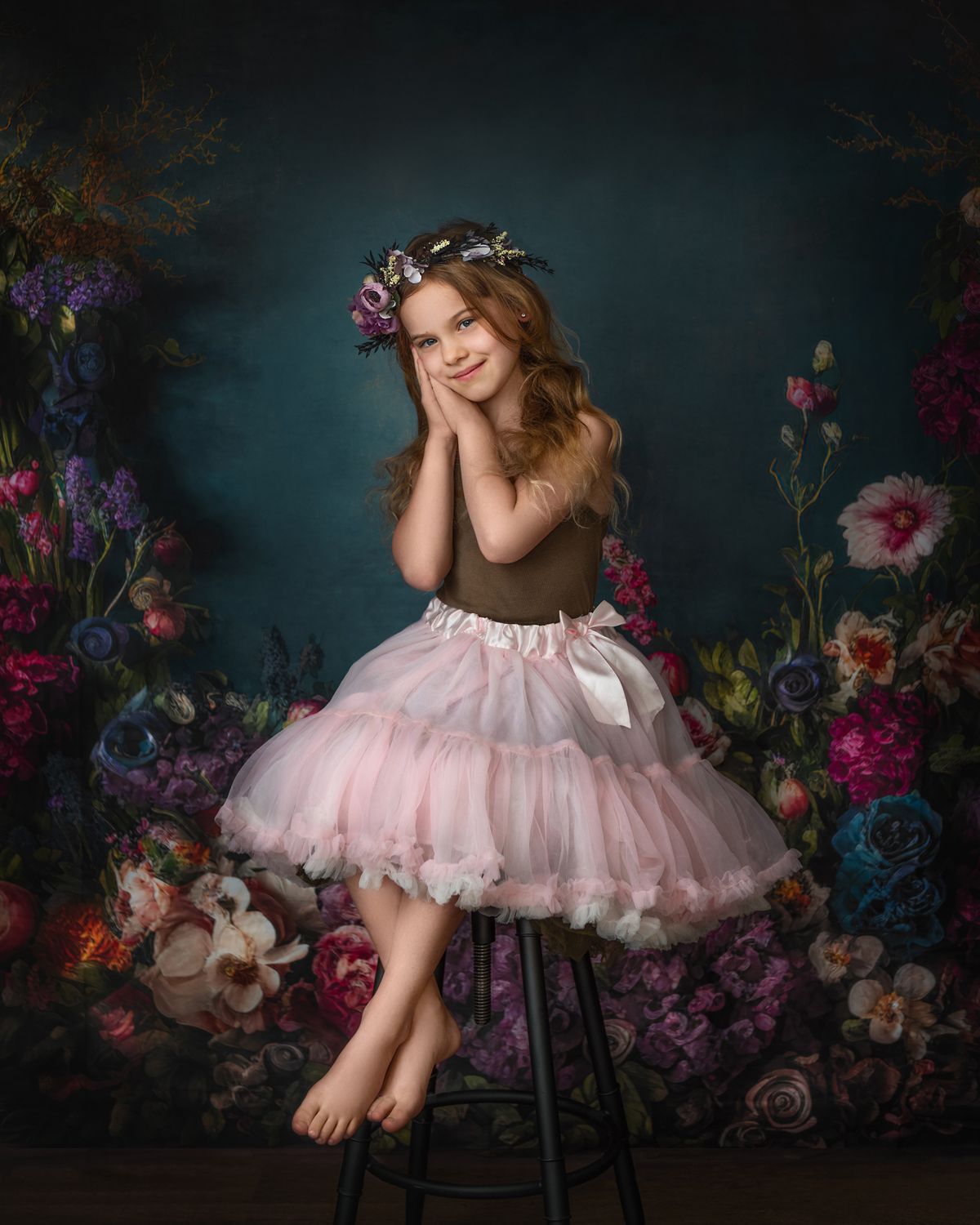 Artistic portrait against dark floral backdrop with pink tulle dress.