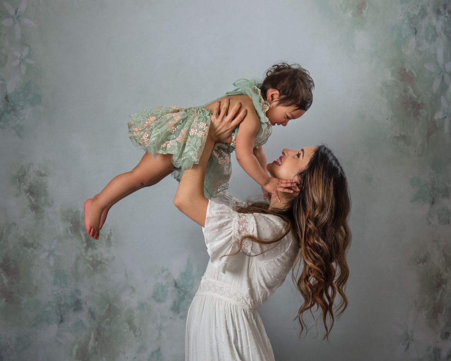 Candid lifestyle photos of parent and child playing against muted floral backdrop.