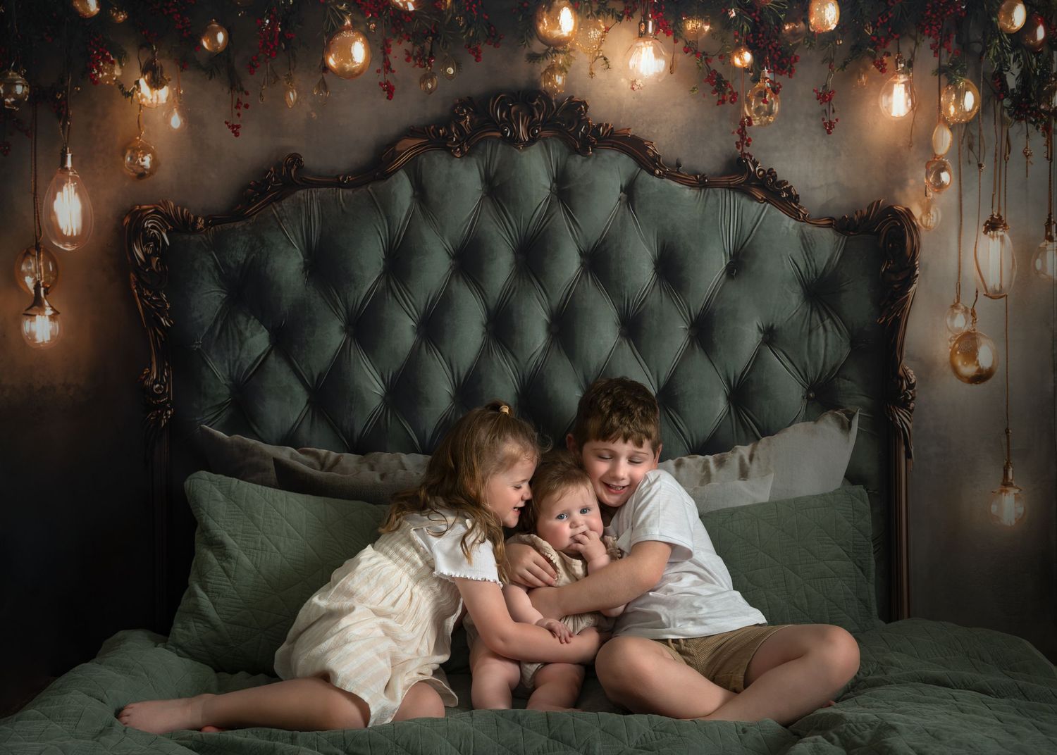 Children rest together on a green tufted couch under warm glowing string lights creating a cozy atmosphere.