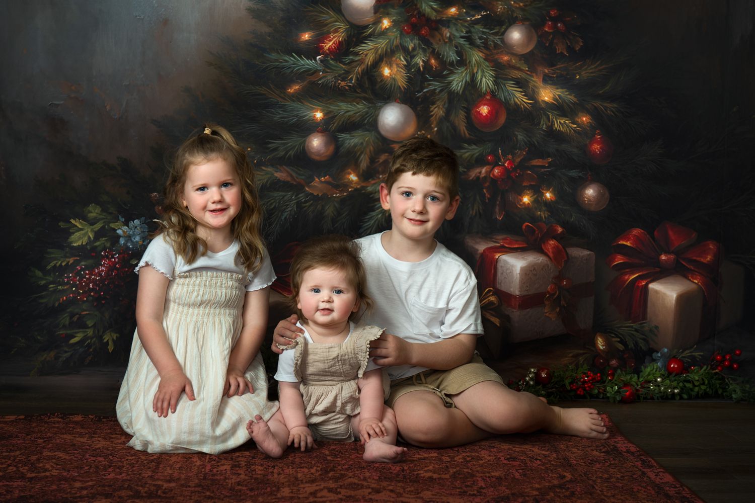 Children pose in front of decorated Christmas tree with presents and holiday decor in dark moody setting.