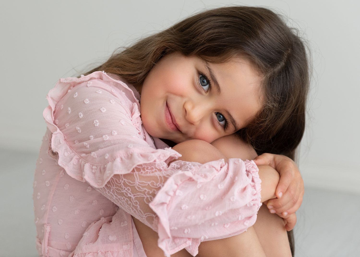 Portrait series featuring soft pink ruffled dress against light background.