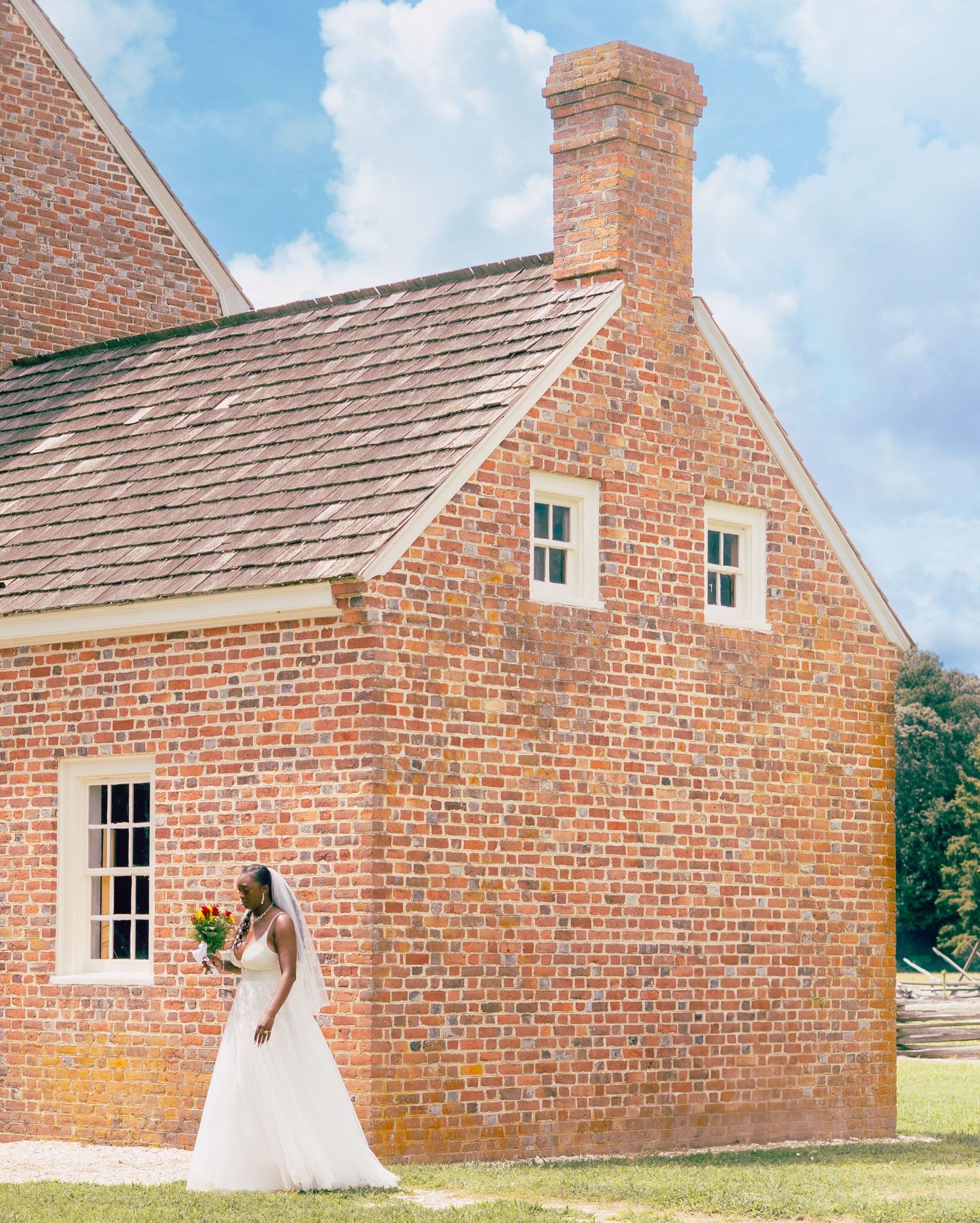 A wedding photo featuring a white dress against the backdrop of a historic brick building.