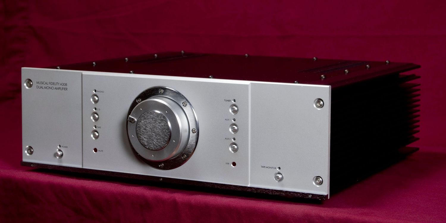 Sleek silver audio equipment component against burgundy background.